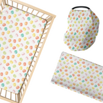 Baby crib sheet, car seat cover, and changing pad cover with colorful macarons pattern on a white background.