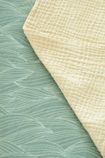 Close-up of textured green fabric with a folded khaki fabric on top