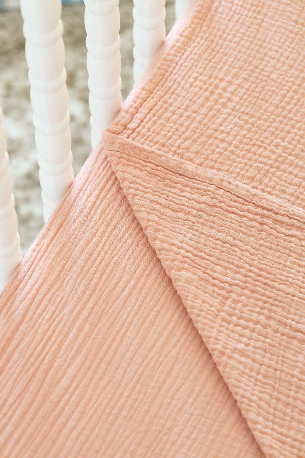 Close-up of textured peach fabric with white woven background