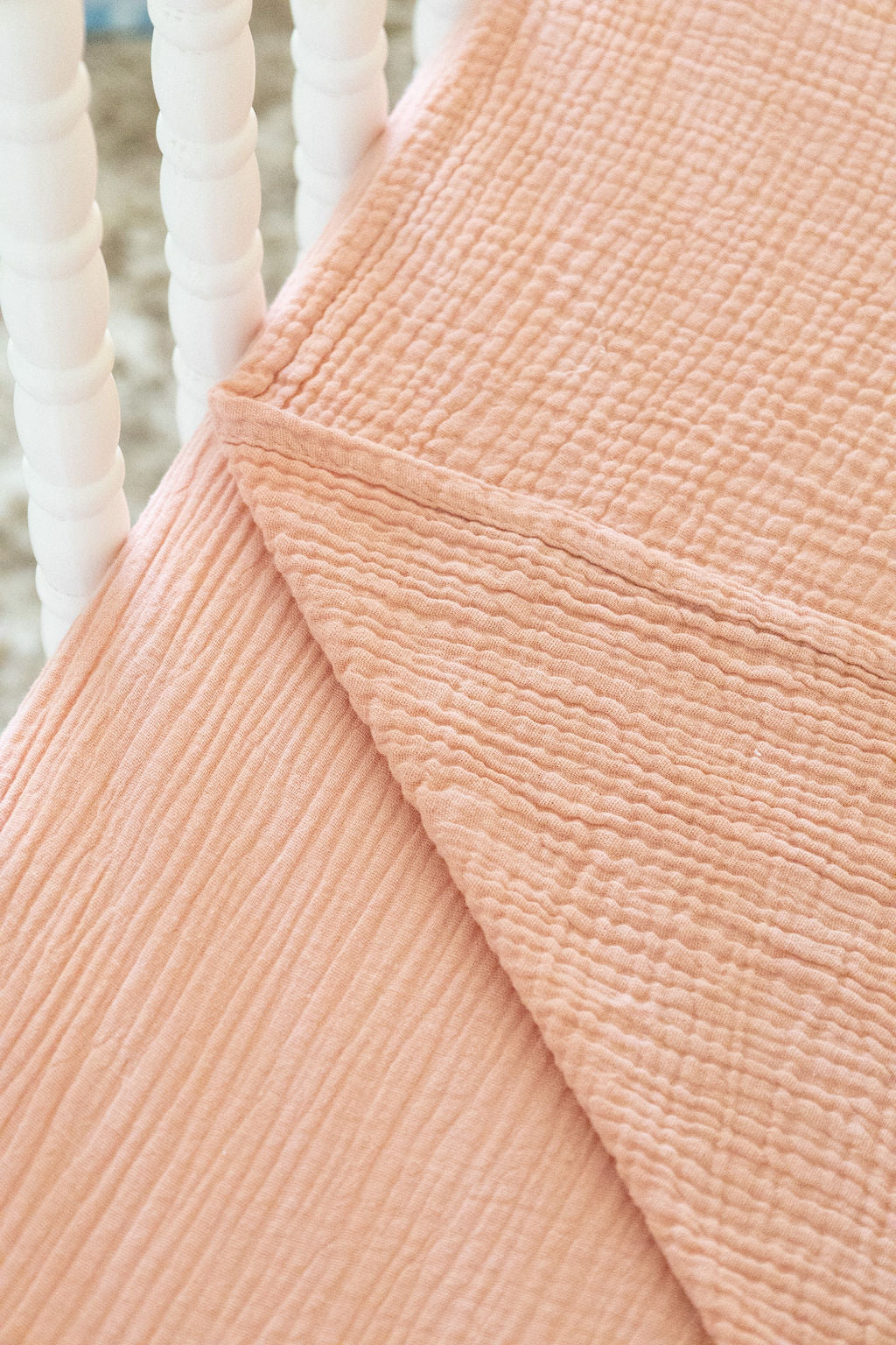 Close-up of a textured peach fabric with a blurred white background