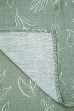 Green fabric with white leaf patterns on a matching background
