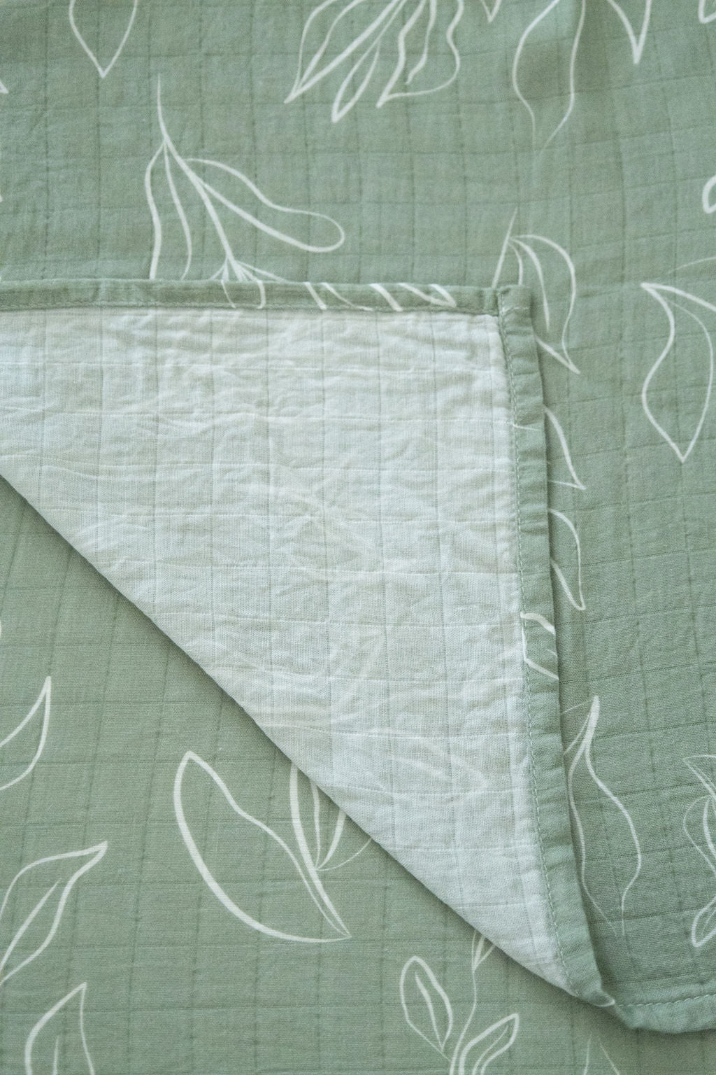 Green fabric with white leaf patterns on a matching background