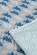 Close-up of a quilt with blue geometric patterns and a textured light blue border.