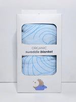 Organic swaddle blanket in packaging with blue pattern on a light gray background
